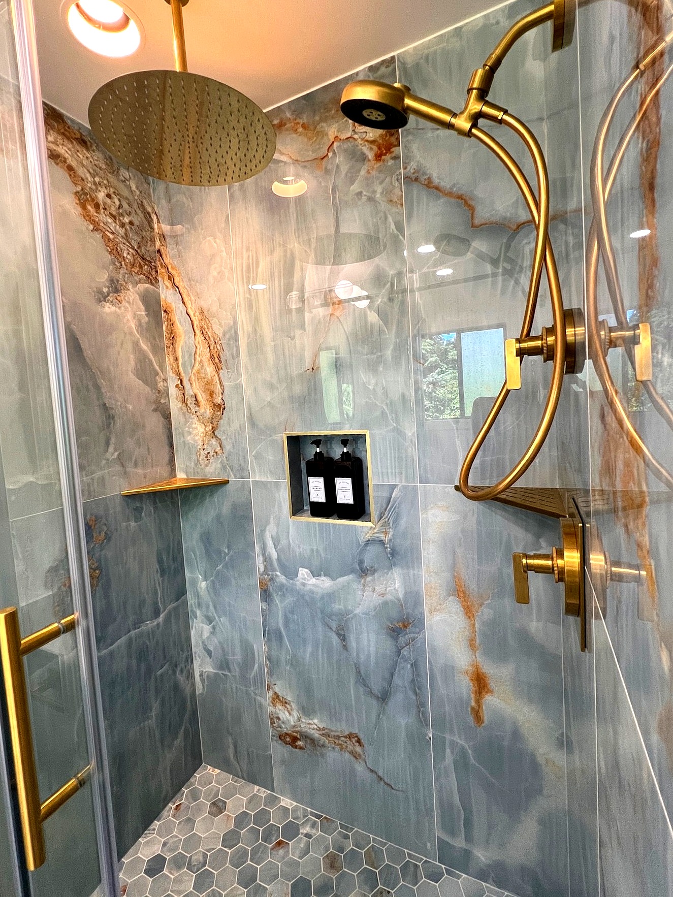Luxury marble shower interior with brass rain head and body jets, Portland OR